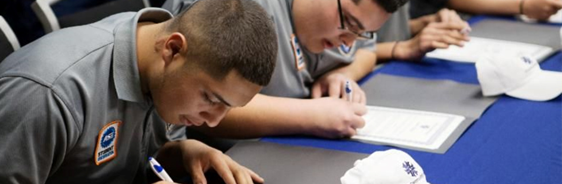 students sign their letters of intent at signing day