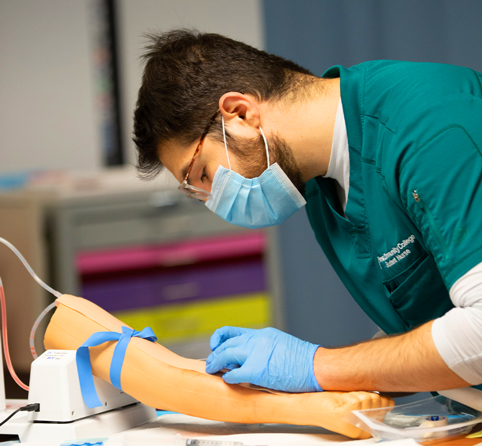 A student gives a immunization to a practice arm 