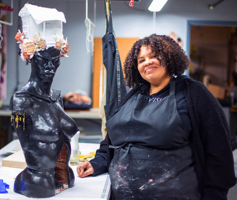 Lizz Denneau in her studio smiling at the camera