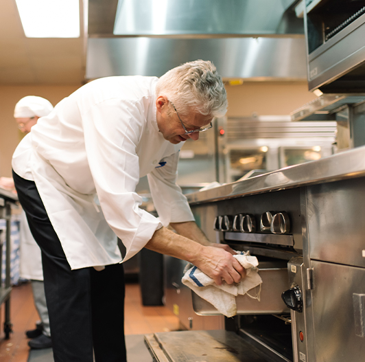 A man pulls a roast from the oven of the culinary kitchen