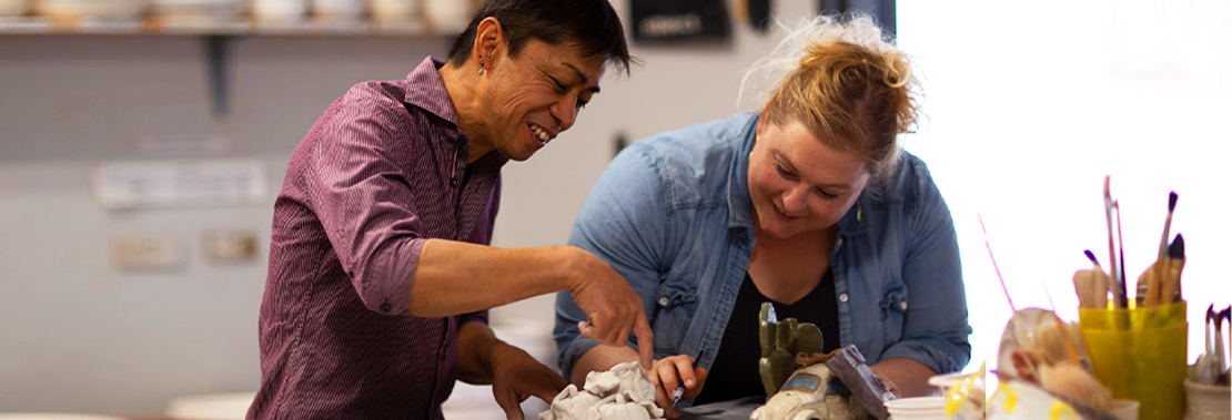 A student and teacher work on a sculpting project together