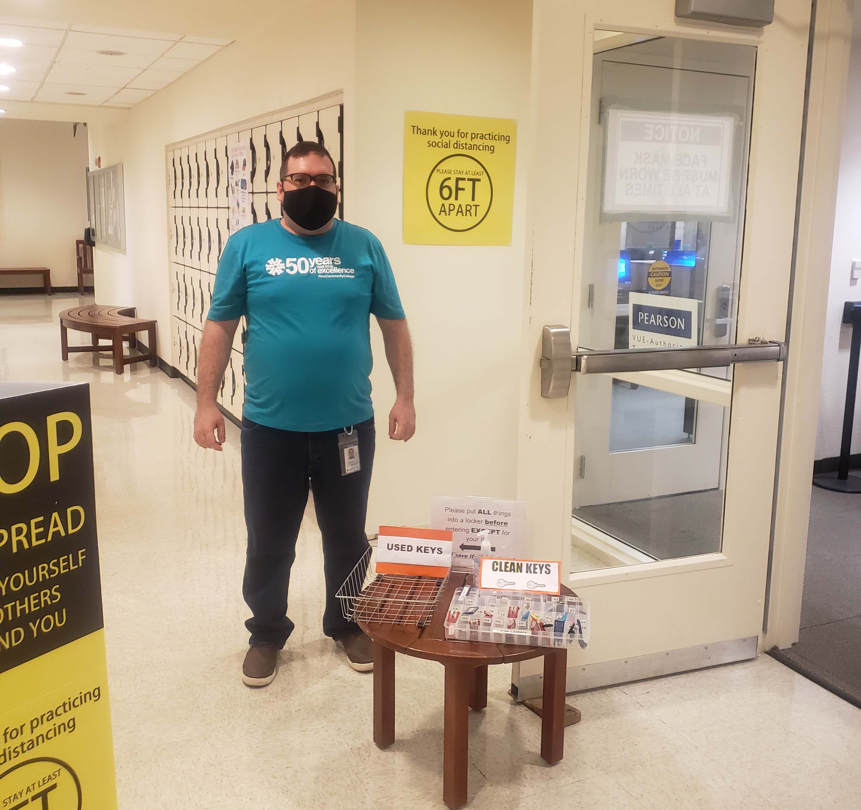 Testing center worker stands in front of door with mask