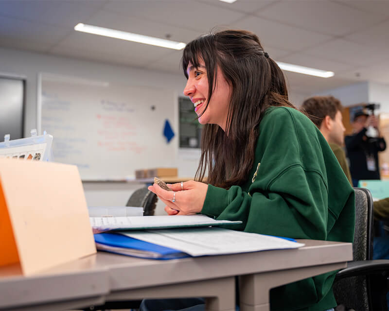 Student sits at a table in the library.