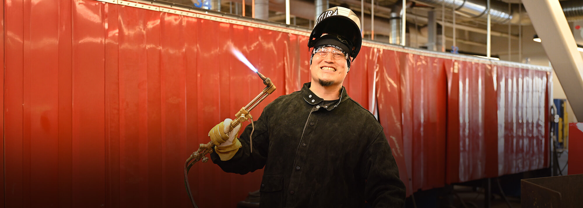 Student wearing protective gear works in the welding lab at Pima Community College.