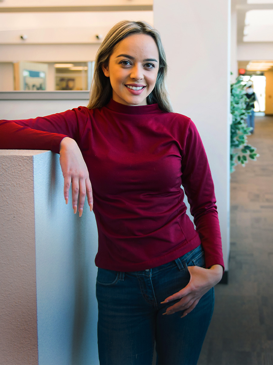 A student stands in a student lounge at a Pima Campus