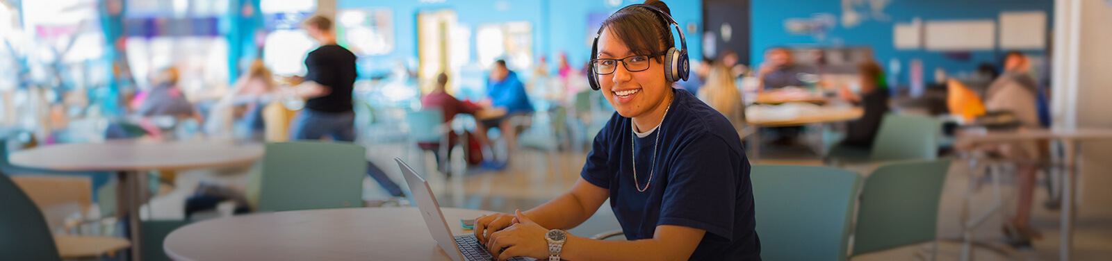 A female student uses a laptop in a Pima Cafeteria