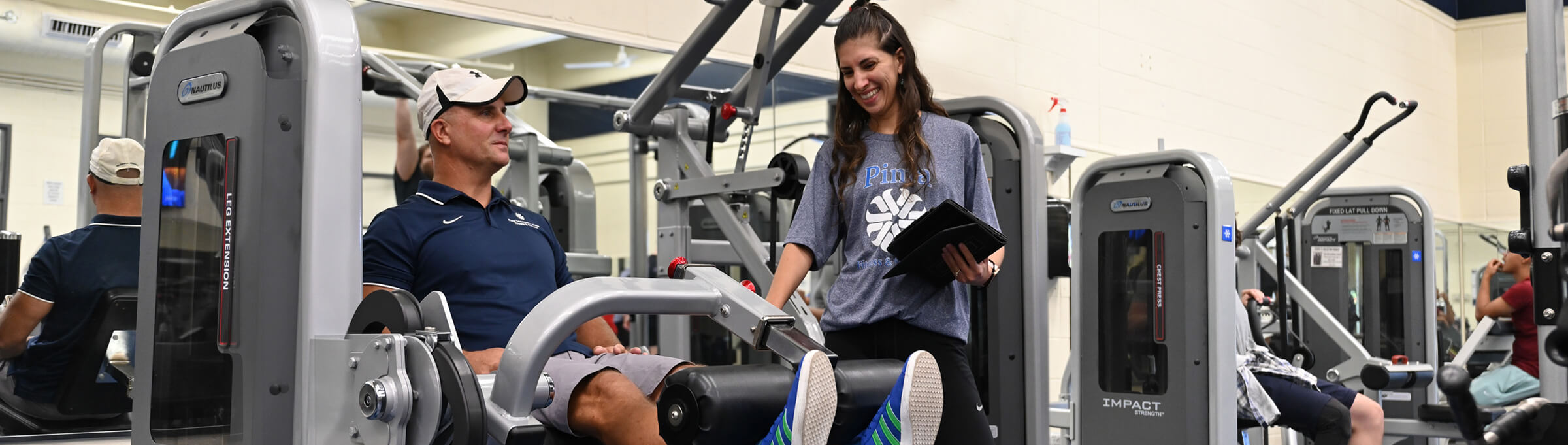 A student assists a teacher as a test with a light fitness workout.
