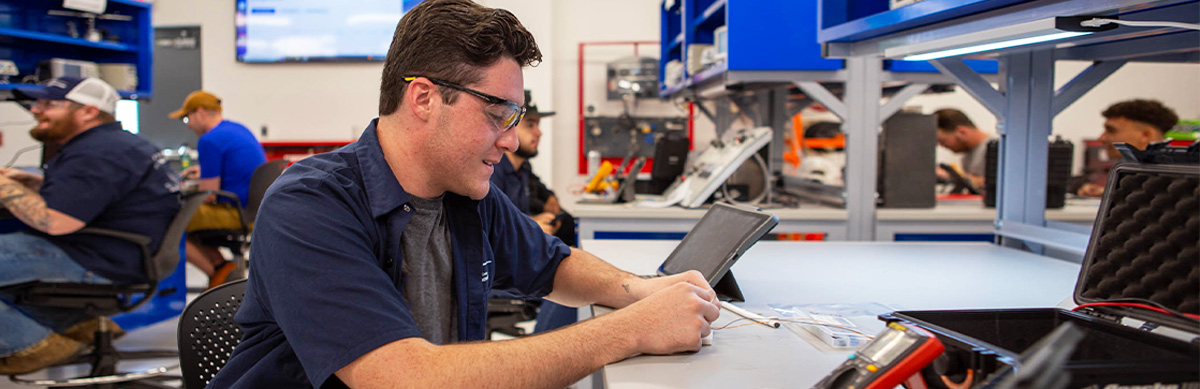 An aviation student works on a device inside an aviation classroom