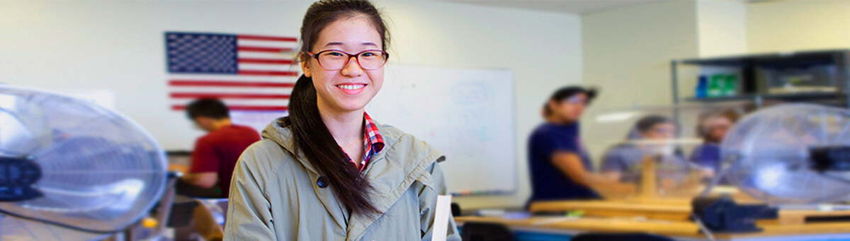 A student stands in front of an engineering lab table in a Pima engineering lab