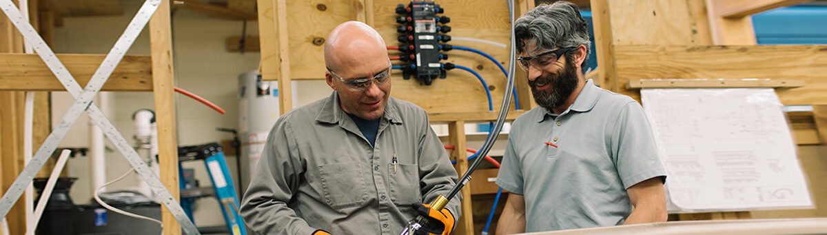 Two men work together inside a Pima facility