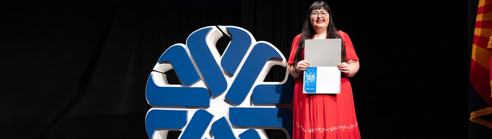 A student Smiles for a photo after accepting the Pima Heroes Award 