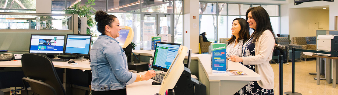 A Student Services Employee helps some students at Pima's Downtown Campus